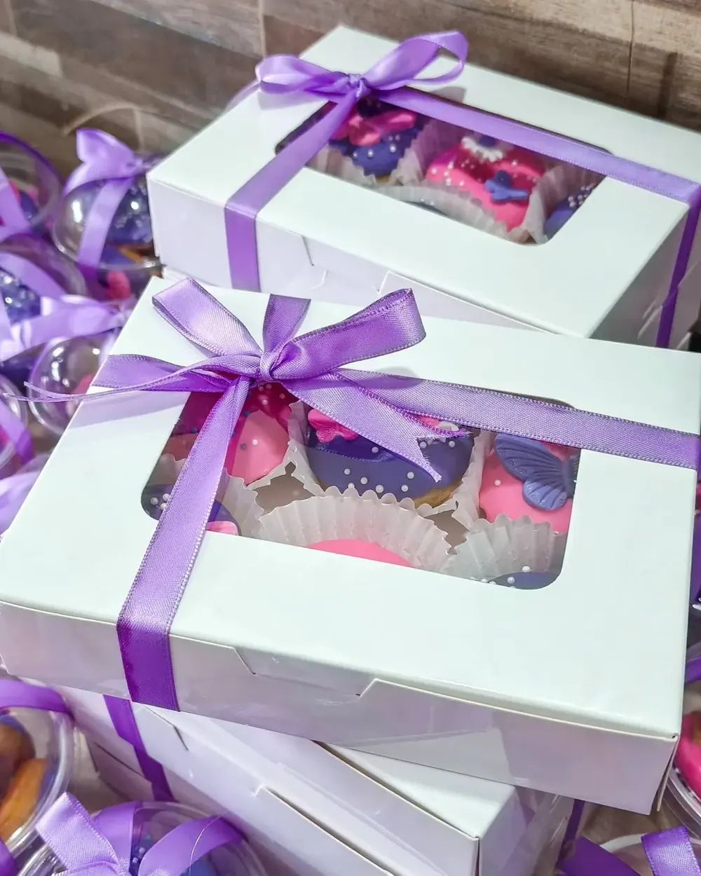 White boxes of mini donuts tied with lavender satin ribbons